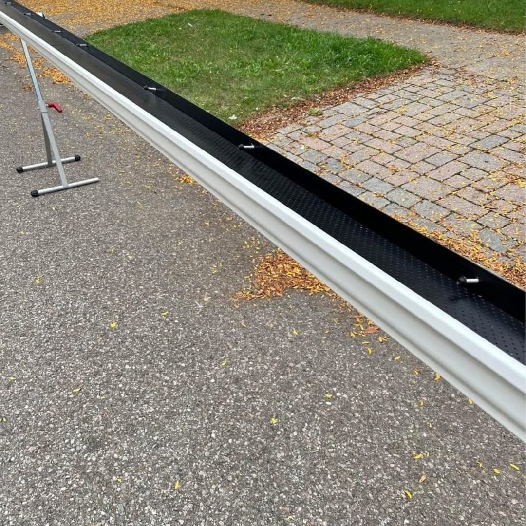 White eavestrough fitted with a black gutter guard